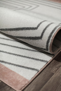 Close-up of a modern rug with black geometric lines on a white background and a brown border, showcasing its texture and design.