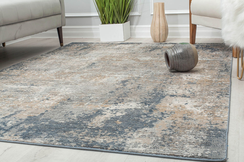 Modern living room with a distressed blue and beige abstract rug, gray sofa, and contemporary decor elements.