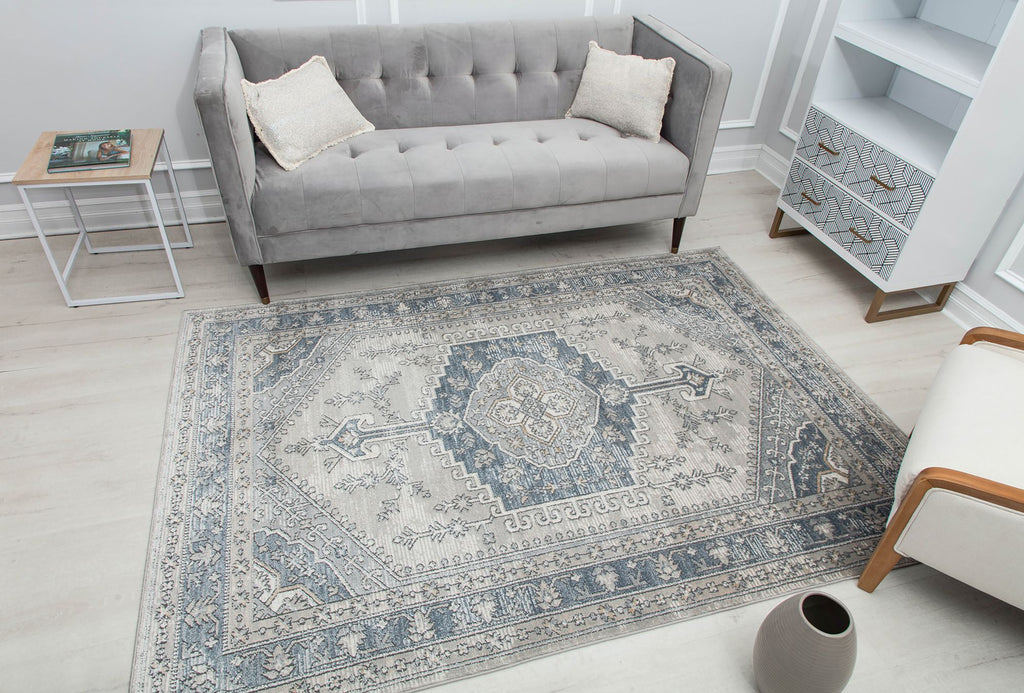 Elegant living room with a gray sofa, a patterned abstract rug, and minimalist decor.