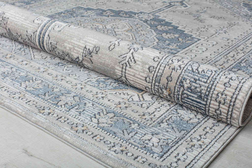 Rolled abstract rug showcasing its detailed blue and beige design.