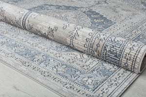 Rolled abstract rug showcasing its detailed blue and beige design.