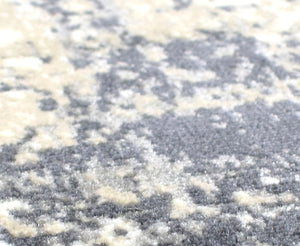 Detailed view of the textured surface of an abstract gray and white rug.