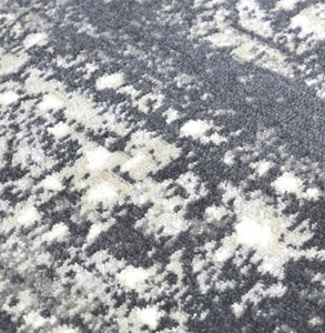 Detailed view of the abstract rug's pattern with shades of gray and white.