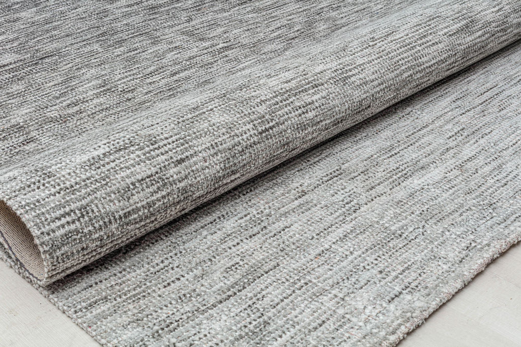 Folded gray area rug showcasing its textured weave.