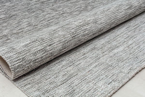 Folded gray area rug showcasing its textured weave.