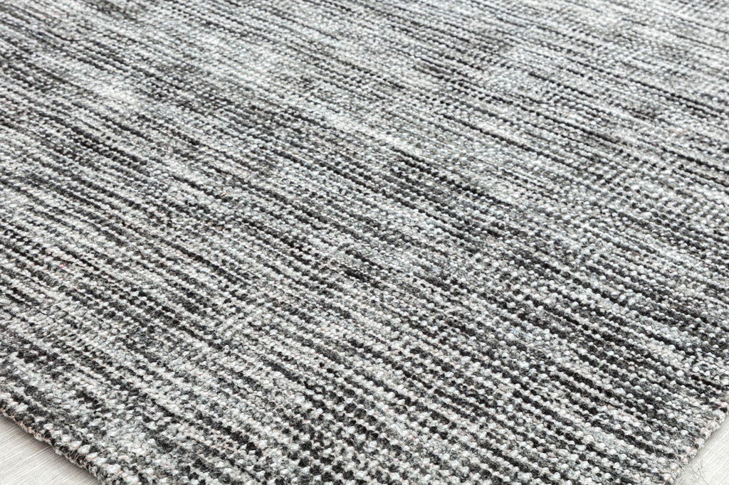 Textured gray area rug on light-colored flooring.