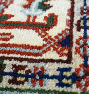 Close-up detail of the vibrant colors and intricate patterns on a blue and red traditional rug.