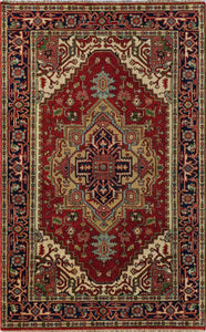 Top view of a small red and blue area rug with detailed, traditional patterns.