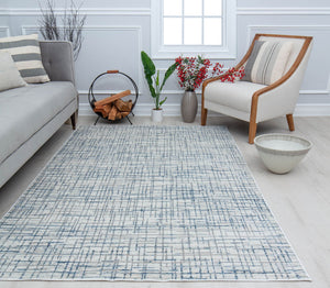 Contemporary living room featuring a patterned abstract rug, grey sofa, striped cushions, modern armchair, and decorative accents