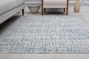 Room view of a blue and gray area rug with a modern geometric pattern, enhancing the contemporary style of the space.