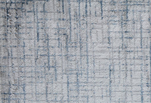 Detailed view of a blue and gray geometric area rug pattern, highlighting its intricate design and texture.