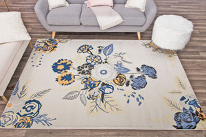 Living room with a floral area rug featuring blue and yellow flowers on a cream background, adding a vibrant touch to the decor.