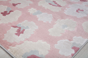 Close-up of the corner of a pink and beige floral patterned rug with abstract flower designs.