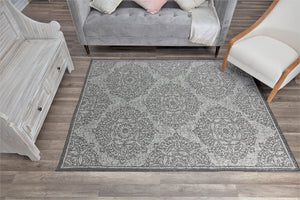 Grey area rug with floral patterns in a modern living room.