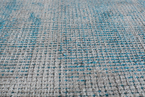 Close-up of a blue and white woven area rug, showcasing its detailed texture and craftsmanship.