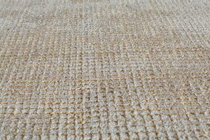 Close-up of a beige woven area rug, showcasing its detailed texture and craftsmanship.