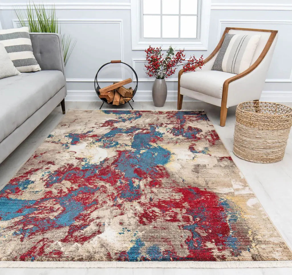 Living room with a modern abstract rug in red, blue, and beige tones, complemented by grey furniture and decorative elements.