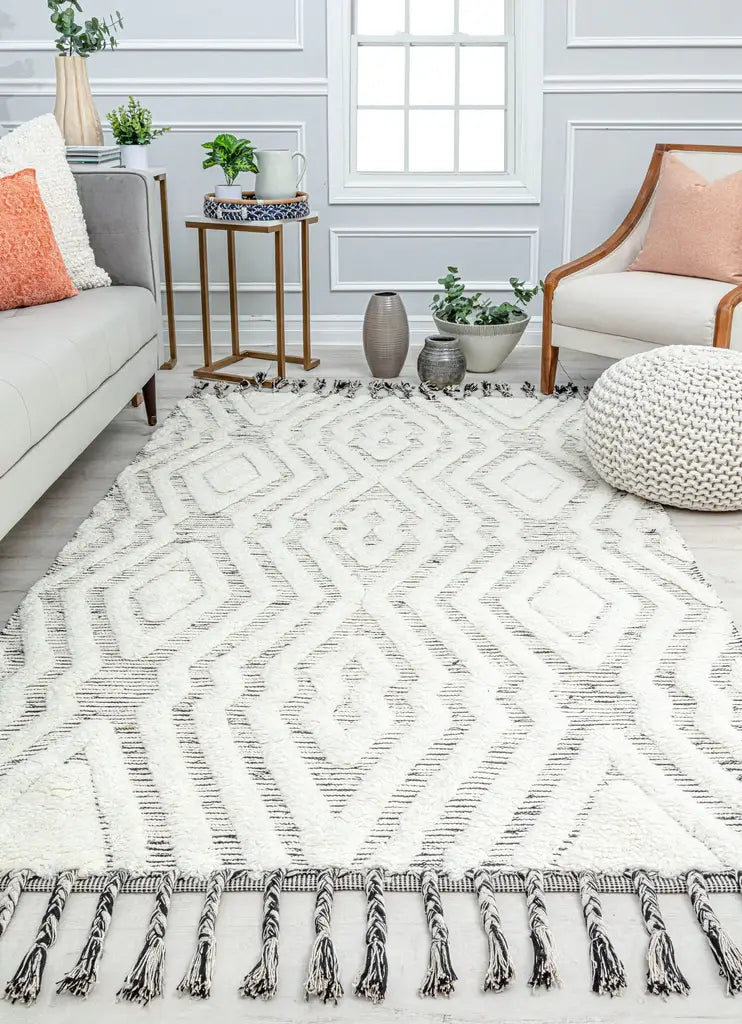 Modern living room with a white geometric patterned rug, cozy seating, and stylish decor elements creating a comfortable ambiance