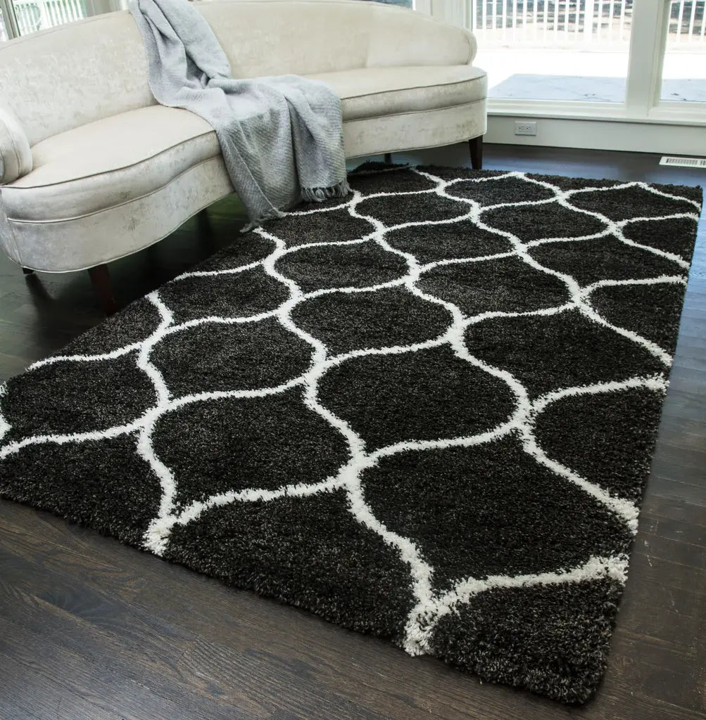 Stylish black and white patterned rug in a contemporary living room, paired with a cream sofa and dark wood floors