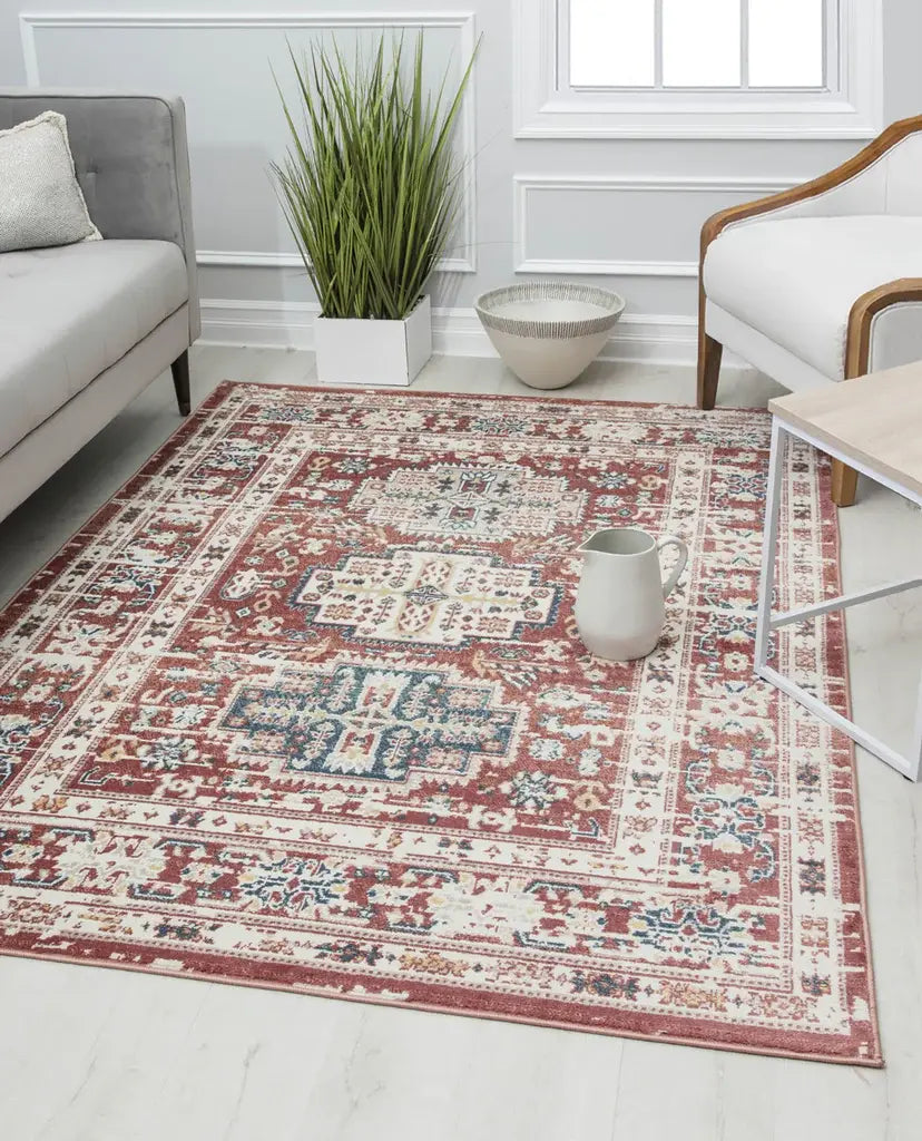 Traditional style Gabriel rug with intricate patterns in a mix of red, blue, and white, featured in a cozy seating area.