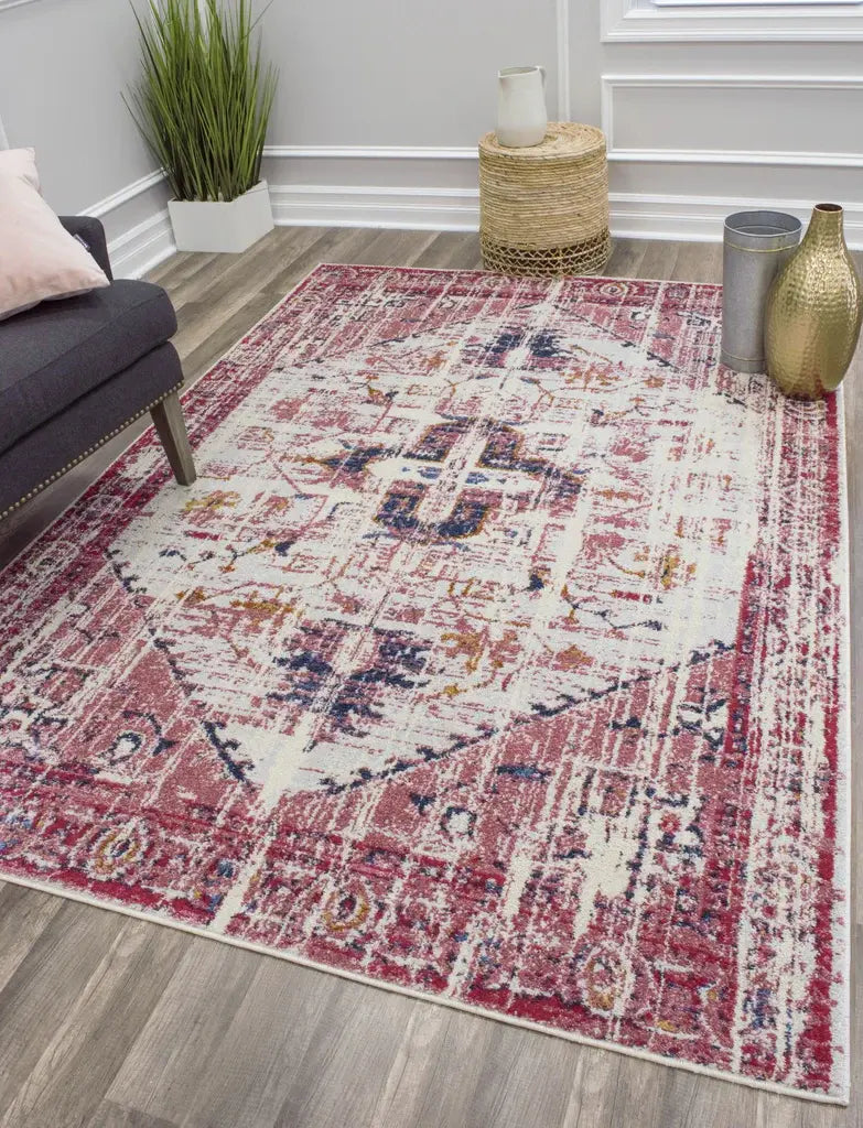 Contemporary living room with a red and white bohemian rug, dark sofa, green plant, wicker basket, and gold vase accents