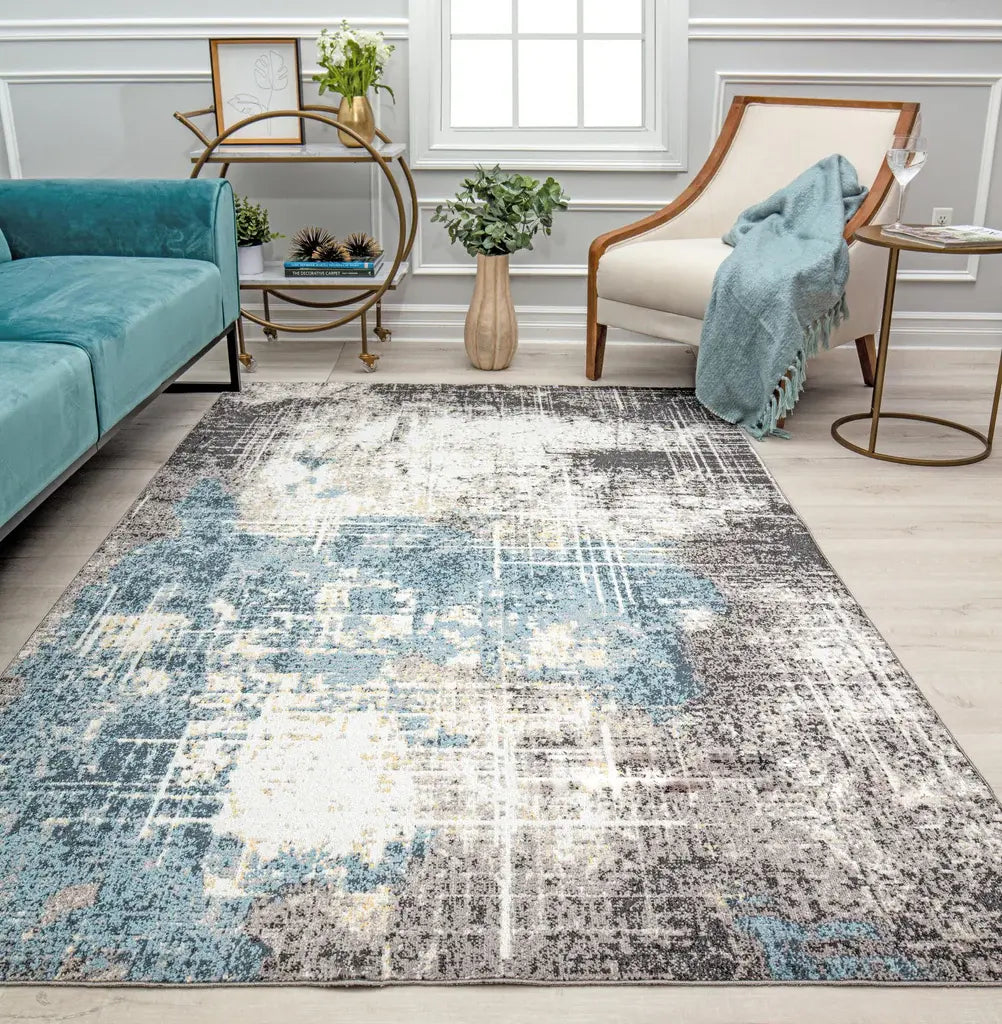 Contemporary living room featuring a distressed blue and gray area rug, a teal sofa, and stylish decor elements for a modern look.