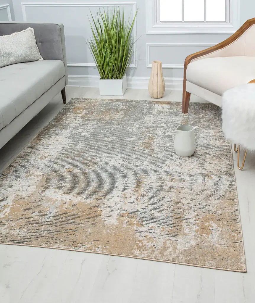 Modern living room with a beige and gray abstract patterned rug, gray sofa, white armchair, and green plant for a chic look