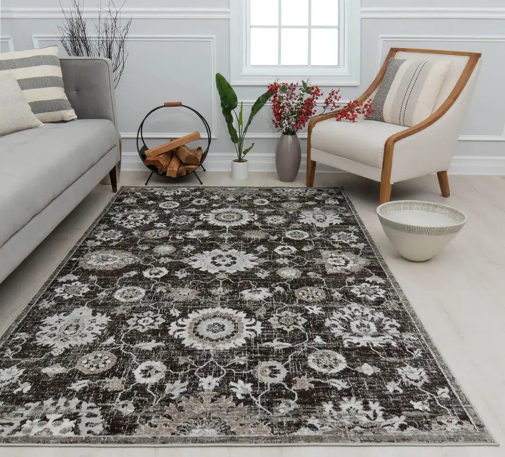 Modern dark floral rug in a cozy living room with a gray sofa, white armchair, firewood holder, and plants against white walls