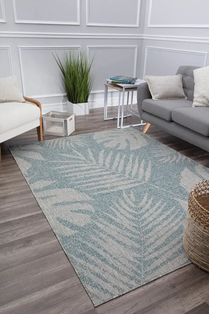 Living room with a modern blue fern area rug, adding a fresh and vibrant touch to the elegant grey and white decor.