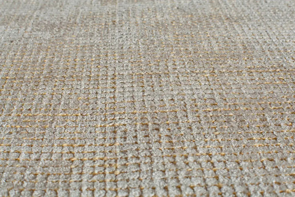 Close-up of a beige woven area rug, showcasing its detailed texture and craftsmanship.